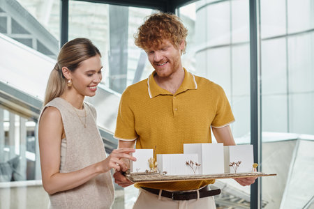 close up of two young creative colleagues working hard on their scale model, design bureau