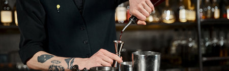 cropped view of bartender pouring alcohol drink into jigger near cocktail shakers in bar, bannerのeditorial素材