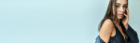 banner of sexy woman with brunette hair posing in leather coat and black corset looking at cameraの写真素材