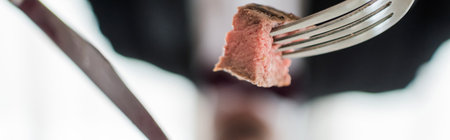 close up shot of medium cooked delicious beef steak and silver knife and fork, gourmet meal bannerの写真素材