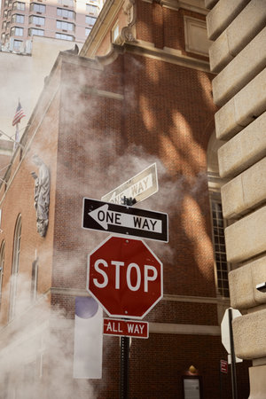 road signs near steam and vintage buildings on street of new york city, urban environment sceneの写真素材