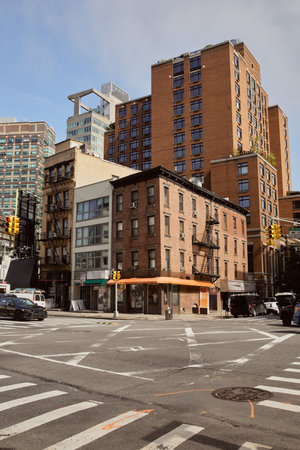 different style buildings near crossroad with moving cars in new york city, urban architecture