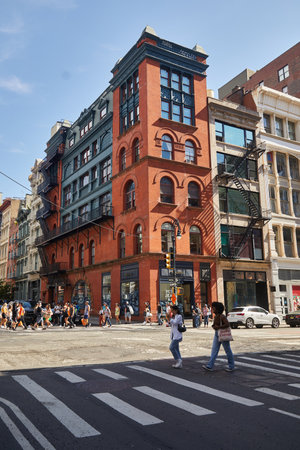 NEW YORK, USA - NOVEMBER 26, 2022: pedestrians crossing wide roadway in downtown on autumn day