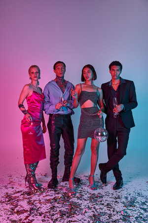 group of interracial friends holding champagne glasses and disco ball on purple pink backdrop