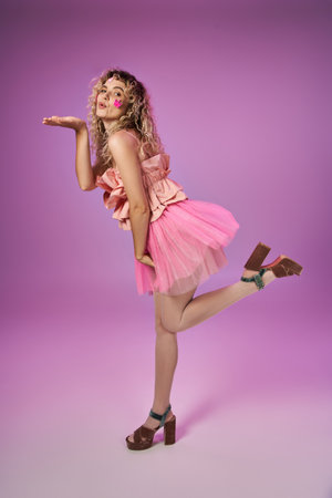 attractive woman in tooth fairy costume with face stickers standing on one leg and blowing kissの写真素材