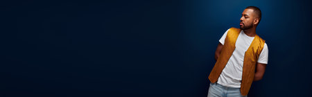 young handsome man in stylish yellow vest posing bending over to side, fashion concept, bannerの写真素材