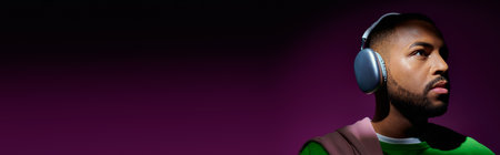 young african american man in green sweatshirt with headphones looking away, fashion concept, bannerの写真素材