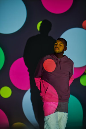 trendy african american male model with closed eyes in digital projector lights, fashion conceptの写真素材