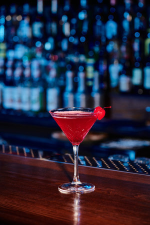 elegant cosmopolitan cocktail in martini glass with cherry on bar counter, conceptの写真素材