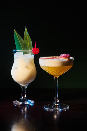 tropical exotic pina colada and daiquiri with fresh garnishing on black backdrop, concept