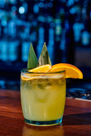 glass of old fashioned cocktail with slice of orange with bar on backdrop, conceptの写真素材
