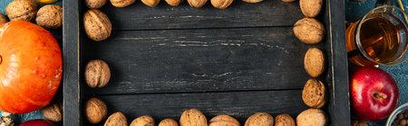 colorful thanksgiving backdrop with walnuts on black wooden tray near fall objects, bannerの写真素材