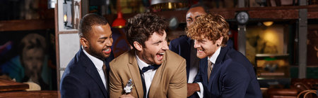 bachelor party banner, excited interracial men congratulating friend in bar, best men tickling groom