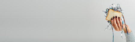 banner of cropped woman holding sandwich with shiny tinsel on grey backdrop, Happy New Year conceptの写真素材