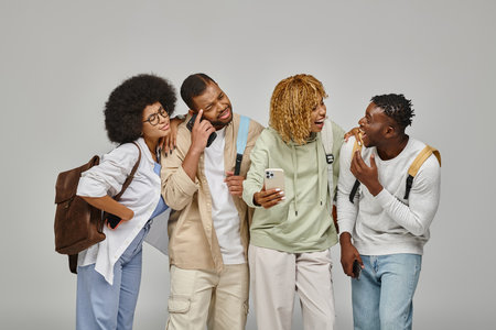 puzzled young group of friends in urban attires with backpacks looking at mobile phone, student