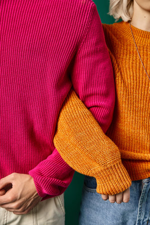 cropped view of young man and woman in knitted winter sweaters posing together, winter fashionの写真素材