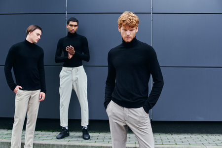 handsome stylish men in black turtlenecks with accessories posing by wall outside, fashion conceptの写真素材
