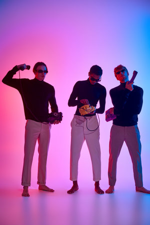 young multicultural male models with stylish sunglasses with land line phones in hands, neon lightsの写真素材