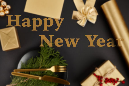happy new year greeting lettering over blurred Christmas background with golden objects on blackの写真素材
