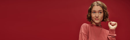 portrait of young pensive woman with short wavy hair looking away on red background, banner