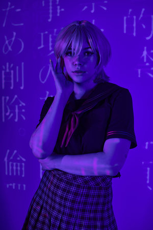 woman in blonde wig and school uniform in blue neon light with hieroglyphs projection, anime trend