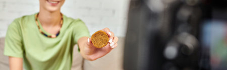cropped view of smiling woman with plant-based cutlet, vegetarian video blog, horizontal banner
