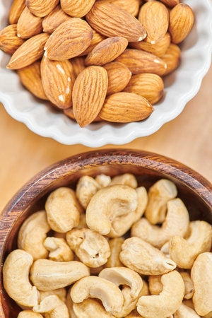 top view of wooden and ceramic bowls with chickpeas and walnuts in bowls, vegetarian conceptの写真素材