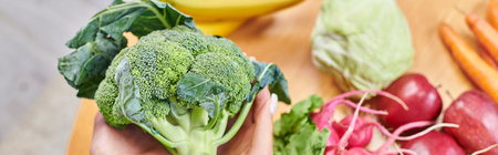 top view of vegetarian woman with broccoli over fresh fruits and vegetables, horizontal bannerの写真素材