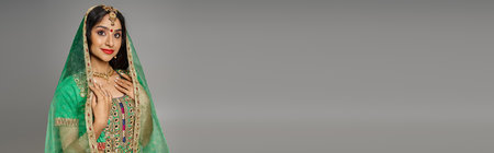 attractive indian woman with bindi dot in national costume and green veil looking at camera, bannerの写真素材