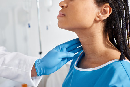 cropped view of sick african american woman when her indian doctor examining her lymph nodesの写真素材