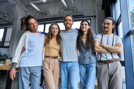 stylish and joyful multicultural managers looking at camera in modern office, successful teamworkの写真素材