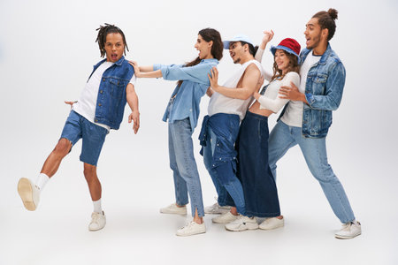 trendy african american man sticking out tongue near cheerful multiethnic friends having fun on greyの写真素材