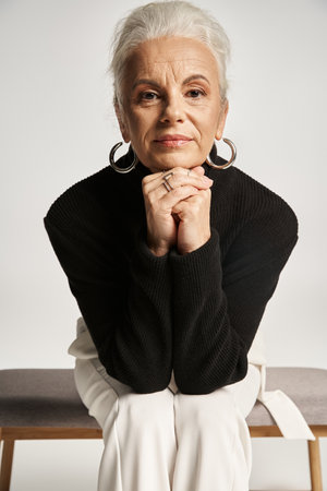 business portrait, middle aged business woman in smart casual attire sitting on indoor benchの写真素材