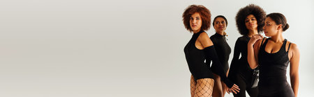 four appealing african american women in black alluring attire posing together, fashion, bannerの写真素材