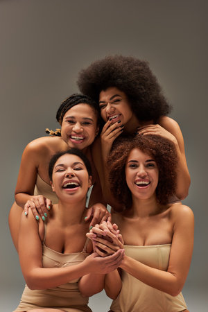 appealing happy african american women in comfy underwear having great time together, fashionの写真素材