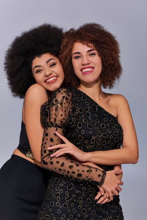 two pretty happy african american women in festive attires partying together, fashion conceptの写真素材