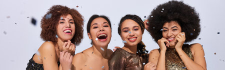 beautiful stylish african american women partying in vibrant attires under confetti rain, bannerの写真素材
