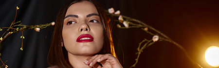 sensual young woman in transparent dress posing near blooming flowers on branches, banner