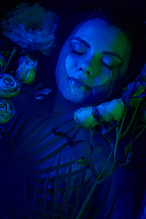 feminine beauty, relaxed young woman lying among palm leaves and flowers in water, diveの写真素材