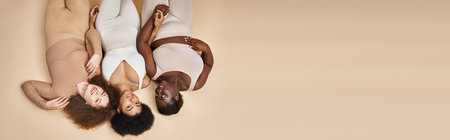 top view of happy plus size woman in lingerie lying down on beige, body positive beauty, bannerの写真素材