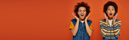 shocked young african american siblings in casual outfits looking surprised, family conceptの写真素材