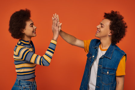 happy young african american siblings in casual attire having great time together, family conceptの写真素材