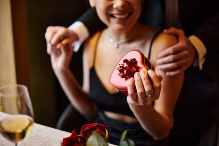 cropped man near happy african american woman holding heart-shaped box on Valentine`s dayの写真素材