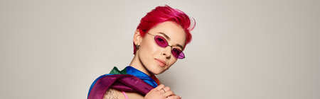 young woman with pink hair and stylish sunglasses posing with lgbt rainbow flag on grey, banner
