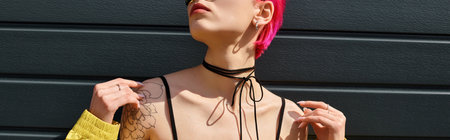 pink haired young woman in yellow sunglasses and stylish outfit posing on urban street, banner