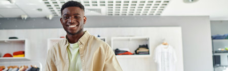 portrait of young african american owner of print studio smiling at camera, horizontal banner