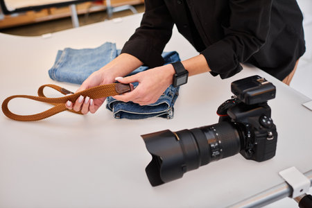 cropped view of young talented female photographer preparing to make object photos on tabletopの写真素材