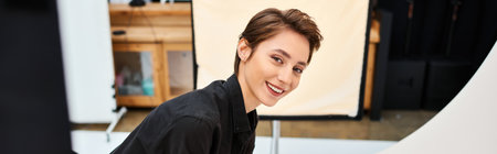 cheerful attractive female photographer preparing to make photos and smiling at camera, bannerの写真素材