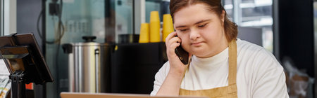 young woman with mental disability talking on smartphone while working in modern cafe, banner