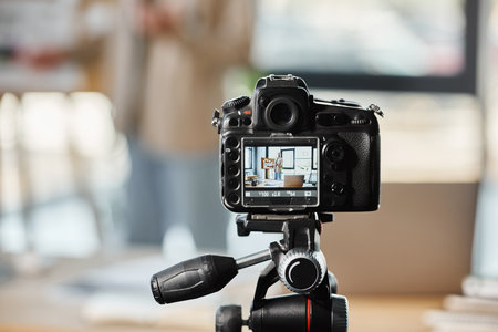 selective focus on digital camera near blurred entrepreneur recording video blog in modern officeの写真素材